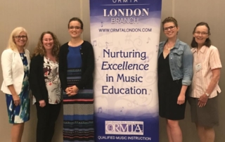 Music teachers standing in group around London ORMTA sign