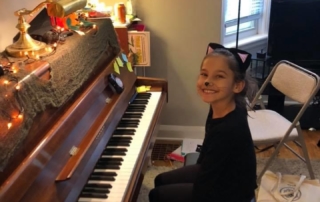 Smiling piano student sitting at piano in halloween costume